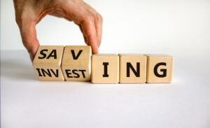 Würfel mit Buchstaben, die die Worte Saving und Investing zeigen
